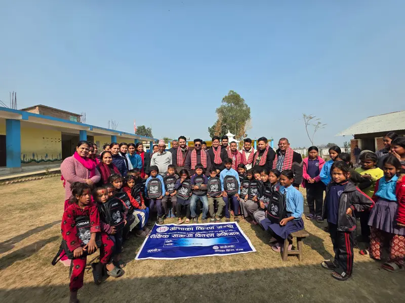 Children, teachers and volunteers gathered at a school for an educational materials distribution campaign.